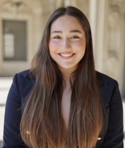 A woman with long brown hair smiling. 